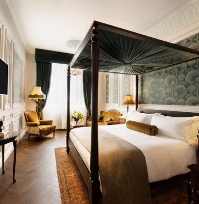 Elegant room with canopy bed, classic decor, plush seating, and soft lighting, perfect for a luxurious stay.