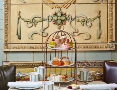 Indulge in an exquisite afternoon tea with delicate pastries and sandwiches on a marble table in a luxurious hotel setting.