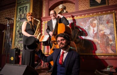 Enjoy a lively jazz trio performing in an elegantly decorated hotel lounge with vibrant art and plush seating.