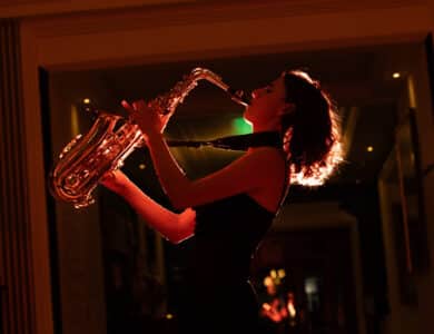 Elegant saxophonist performs in warm, ambient hotel lounge. Enhancing the perfect evening with live jazz music.