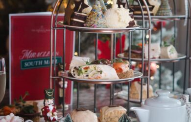 Festive afternoon tea with sandwiches, pastries, and holiday decor at a cosy hotel lounge.