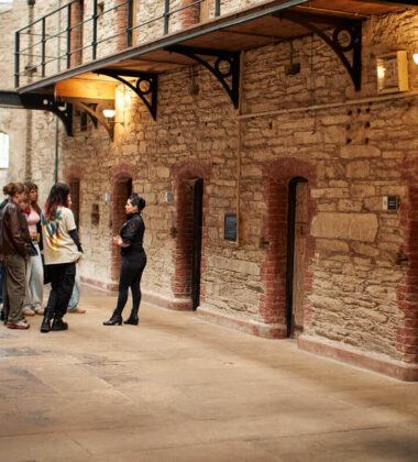 Guests explore historic stone-walled interiors of a unique hotel with warm lighting and cosy atmosphere.